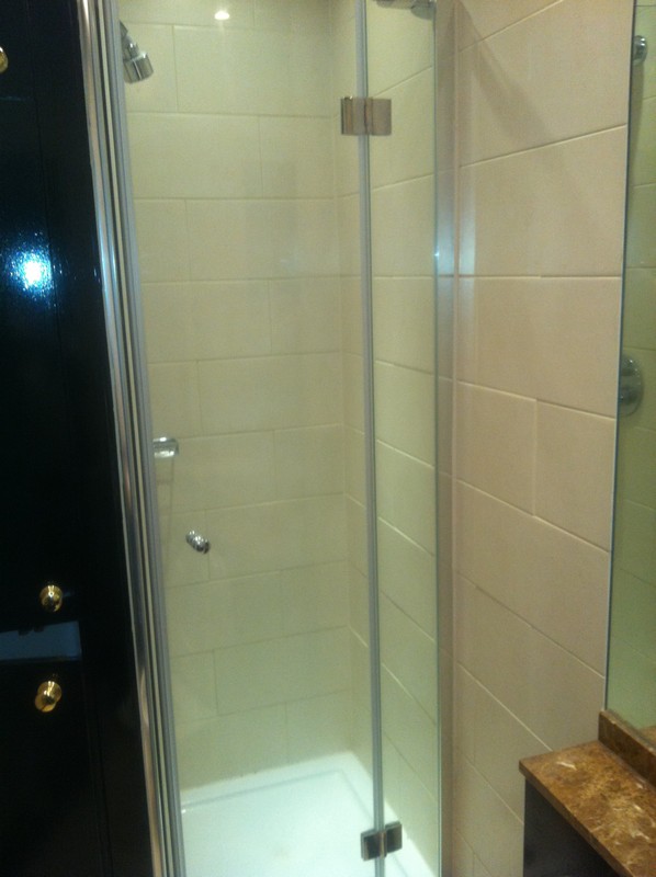 Frameless glass shower enclosure with chrome fittings in West Kensington